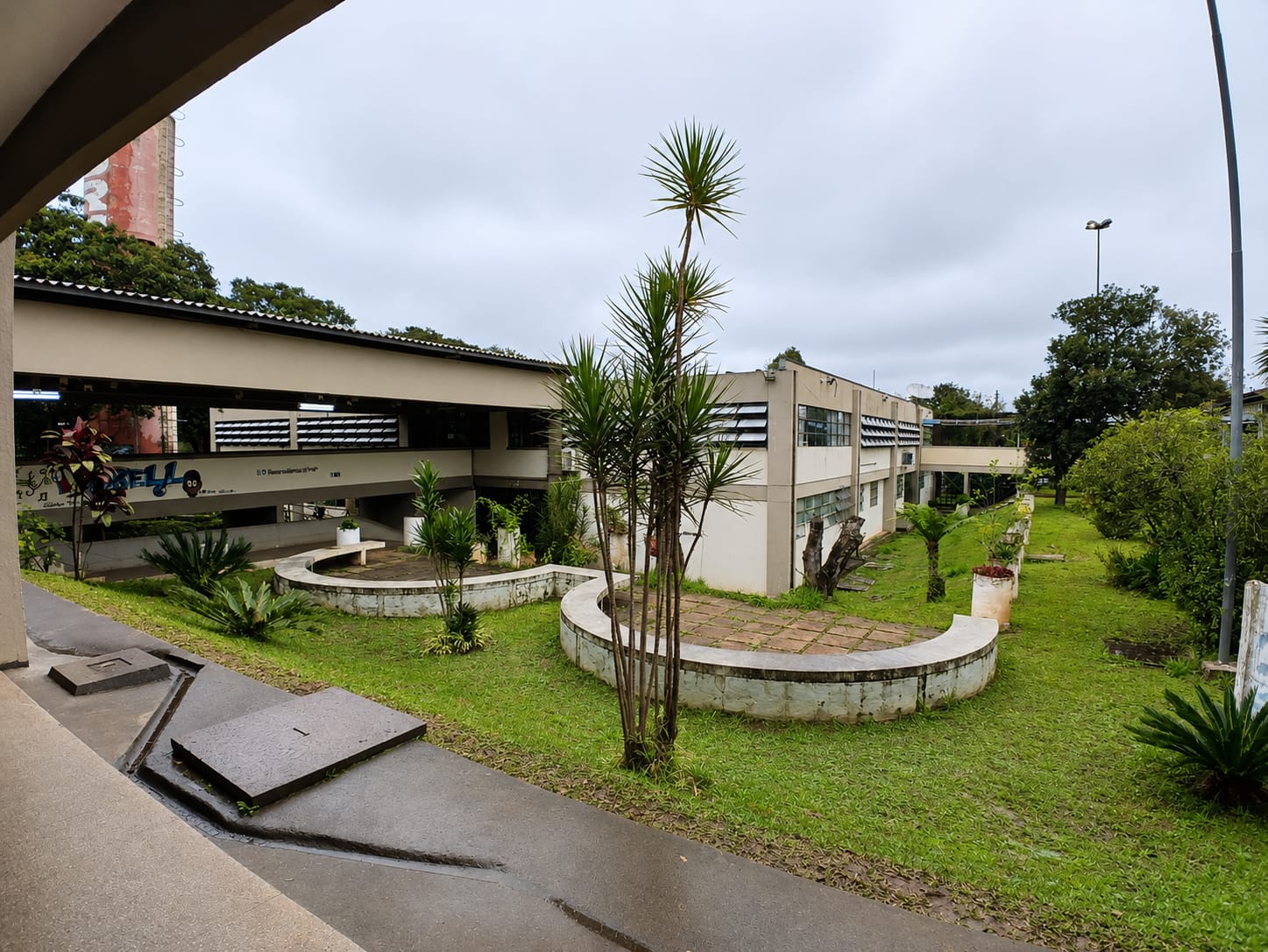 Fachada de escola pública com estudantes chegando para as aulas